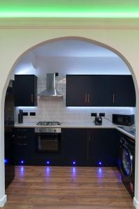 利兹Kitchener house的厨房配有黑色橱柜和炉灶烤箱。