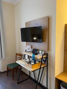 波茨坦老城酒店的客房设有一张桌子,墙上配有电视