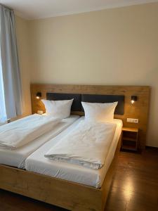 波茨坦老城酒店的一间卧室配有两张带白色床单的床
