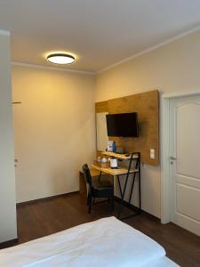 波茨坦老城酒店的客房设有一张书桌、一台电脑和一张床
