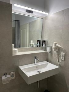 波茨坦老城酒店的浴室设有白色水槽和镜子