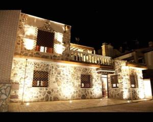 ArgésCasa Rural El Rosal del Pozo, a 5 minutos de Puy du Fou的一座石头建筑,晚上有灯