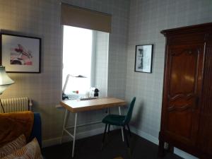 塔朗"la suite"的客房设有书桌、窗户和椅子。