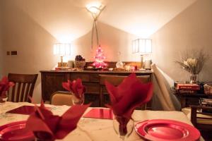 斯特拉斯佩弗The Brunstane Lodge的一间用餐室,配有红色盘子和圣诞树的桌子