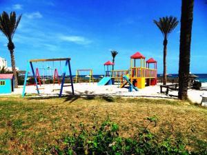 杰尔吉斯Zita Beach Resort的棕榈树和海洋海滩上的游乐场