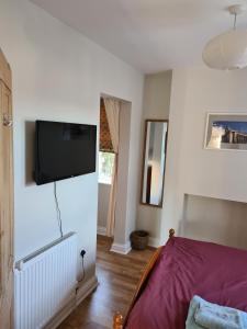 诺丁汉Bramblhen的卧室配有一张床和壁挂式平面电视。