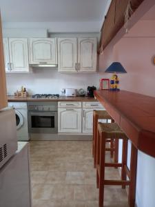 拉戈斯Villa Brito的厨房配有白色橱柜和木制台面