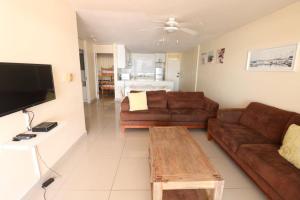 乌姆德洛蒂Cozumel 311的客厅配有2张棕色沙发和1张桌子