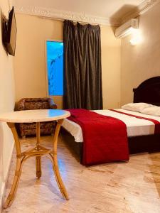 卡萨布兰卡SINGAPOUR MAROC的一间卧室配有桌子、床、桌子和椅子