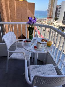 贝尼多姆黄金酒店的阳台配有桌椅和鲜花