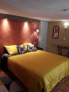 ChâteauvieuxGite les Cigales的卧室配有一张带黄色床单和枕头的大床。