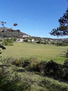 ChâteauvieuxGite les Cigales的山丘上带房子的绿色田野