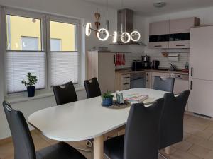 韦森贝格Ferienhaus Meier的厨房配有白色的桌子和黑色的椅子