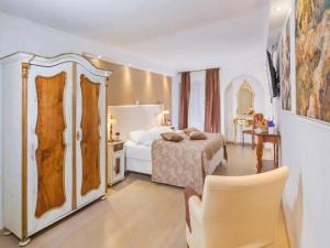 罗维尼Heritage Hotel Villa Valdibora的卧室配有1张床、1张桌子和1把椅子