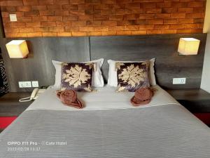 怡保怡保可爱酒店及旅馆的一张带两张毯子和枕头的床