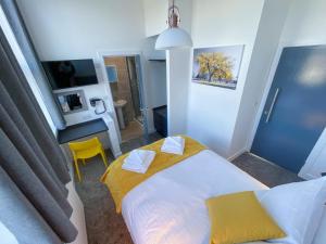 普里茅斯Victoria by Pureserviced的一间小卧室,配有一张床和一张黄色椅子