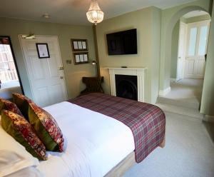 温彻斯特维克汉姆阿姆斯酒店的卧室配有白色的床和壁炉