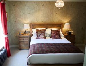 温彻斯特维克汉姆阿姆斯酒店的一间卧室配有一张带2个床头柜和2盏灯的床。