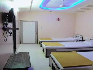 孟买Hotel Broadway Colaba的一间医院,配有四张床和蓝光