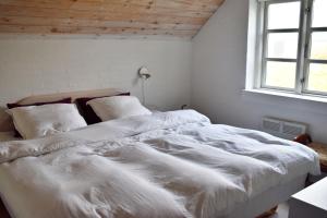 克利特默勒Viking Surf Cottage的白色卧室设有两张床,配有窗户