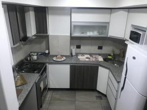 里瓦达维亚海军准将城Espacio Chacabuco的厨房配有白色橱柜和柜台上的一盘食物