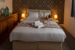 滨海戈尔斯顿Trafalgar House的一间卧室配有一张大床和毛巾