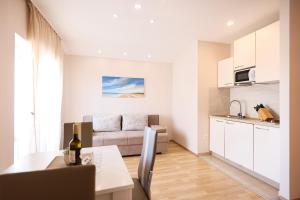 沃希Apartments Anka with Seaview的厨房以及带桌子和沙发的客厅。