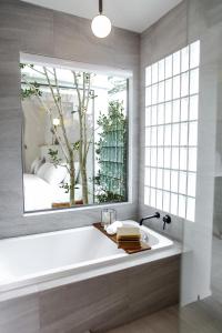 甘烹碧La Kana Boutique Villa的一间带大窗户和浴缸的浴室