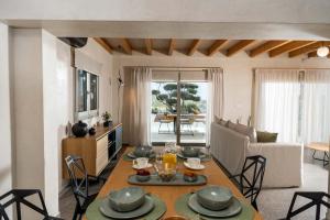 伊罗达The Olive Tree Villa Elounda的厨房以及带桌椅的起居室。