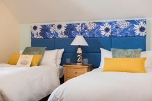 帕兹托Padstow 2 bedroom Lodge at Retallack Resort的一间卧室设有两张床和蓝色床头板