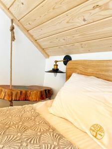 亚沃尔基Dziejba Leśna Apartamenty &Spa的一间卧室设有一张床和木制天花板