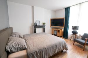 RekemBrasserie Sint Pieter的一间卧室配有一张床、一台电视和一张沙发