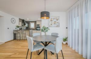 奈维斯Villa Njivice Apartman Marina的一间带桌椅的用餐室和一间厨房