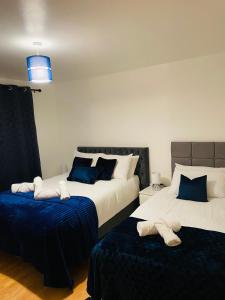 唐克斯特Cheerful home near City Centre,Station& RaceCourse的一间卧室配有两张蓝色和白色的床