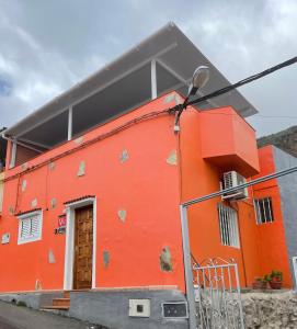 巴尔塞基略Chalet Rutas de Valsequillo的橙色的建筑,有门和街灯