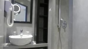 佩罗斯-吉雷克Logis Hôtel Saint Guirec Et De La Plage的浴室配有盥洗盆和带镜子的淋浴