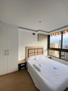 贝尼多姆El Apartamento de Cristian 3的一间卧室设有一张大床和一个大窗户