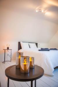 梅赫伦Huis ALNA 1的一间卧室配有一张桌子上的蜡烛床