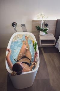 托尔博莱GoTì Hotel的女人躺在浴缸里