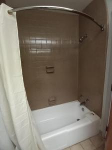 彼得斯堡Travelodge by Wyndham Petersburg的带淋浴的浴室配有白色浴缸。