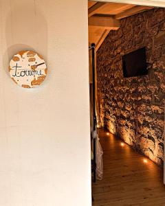 圣特雷莎加卢拉B&B Anastasia的一间墙上有石墙的房间,墙上有时钟