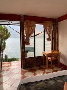 圣佩德罗拉拉古纳Hotel Villa del Lago, Gladys的一间卧室配有一张桌子,享有水景