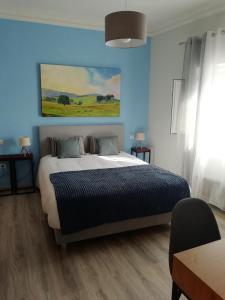 新文达什Casa Fisher的一间卧室设有一张蓝色墙壁的大床