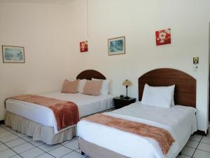 危地马拉Novohostal B&B的白色墙壁客房的两张床