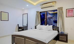 钦奈FabHotel Skyry的卧室设有一张白色大床和一扇窗户。