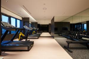 城南市九树精品酒店首尔板桥的健身房设有一排跑步机和椅子