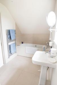 普尔伯勒The Countryside Annexe的白色的浴室设有水槽和浴缸。