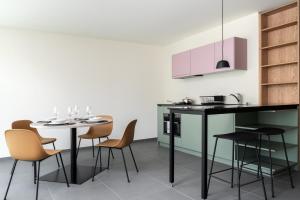 圣莫里茨Townhouse N9的厨房配有桌椅和粉红色橱柜。