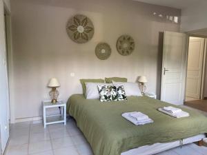波尔蒂乔Villa 180 m2 vue Mer au calme grand terrain Porticcio的一间卧室配有绿床和2条毛巾