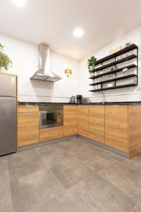 毕尔巴鄂Unamuno by Bilbao Living的厨房配有木制橱柜和不锈钢冰箱。